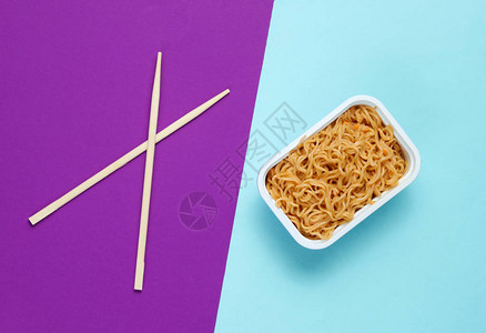 蓝紫色背景的方便面和筷子图片