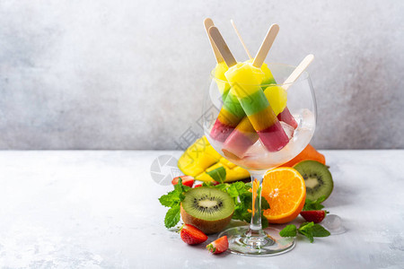 葡萄酒杯中含有不同口味芒果橘子木薯和草莓的花瓶夏季食品概念图片