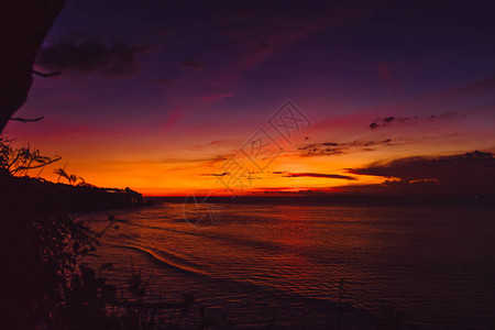 热带岛屿的海洋和海浪的明亮日落图片