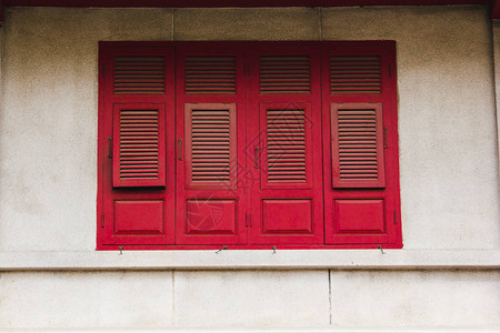 白墙上的旧红色木窗图片