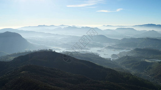 早晨阳光照射的山谷景色从亚当斯峰或斯里帕达的全景新鲜的雾山景观大多以柔和的蓝色背景图片