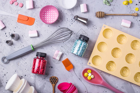 制作甜点和糖果的工具粉末和装饰品勺子松饼模具糖衣在灰色的背景上图片
