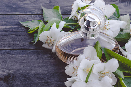 香水瓶含木本底的茉莉花女香背景图片