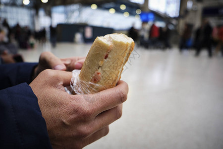 在火车站或电车站里吃三明治的天主图片