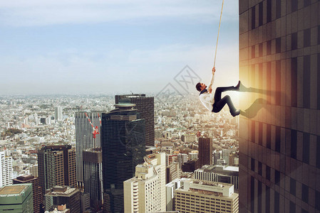 商人用绳子爬上高楼决心的概念高清图片