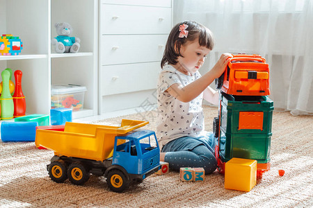 童年和人的概念是一个快乐的三岁女孩在家里玩具车女孩为男孩玩游图片