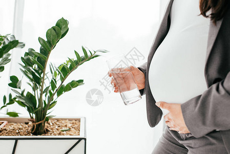 孕妇用玻璃和水装着玻璃图片