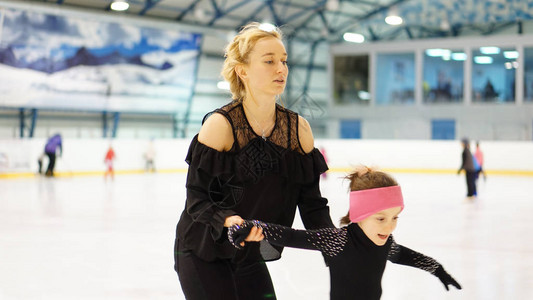 花式滑冰训练中女教练在室内溜冰场训练穿黑色紧高清图片