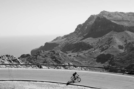 骑自行车的运动员在山区公路上高速赛跑背景图片