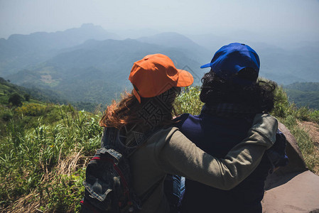 情人夫妇男女亚洲人旅行在假期放松坐在山上看风景山公园开心在山上图片