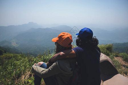 情人夫妇男女亚洲人旅行在假期放松坐在山上看风景山公园开心在山上图片