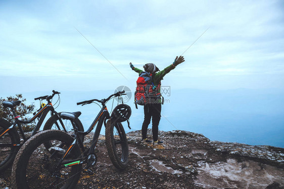 亚洲女人旅行照片自然旅行放松在野外骑自行车荒野站在岩石图片