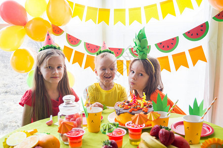 孩子们庆祝生日孩子吹灭蛋糕上的蜡烛水果派对菠萝西瓜装儿童节图片