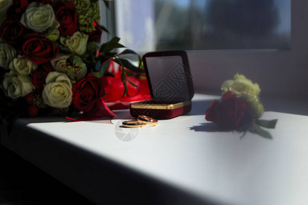 窗户上是结婚戒指有红花和白玫瑰的花朵图片