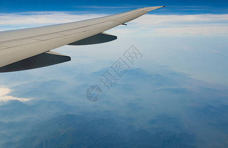 飞机翼在山上飞机在蓝天白云上飞行从飞机窗口的风景商业航空公司航班飞机翼飞行力学概背景