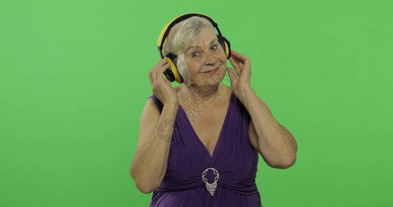 老年妇女用耳机听音乐图片