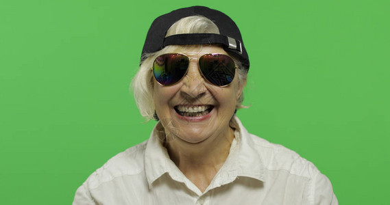 身戴太阳镜和帽子的年长妇女笑容图片