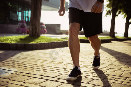 作为城市街道的赛跑者的老人近距离拍摄鞋的腿白种人男在夏天的早晨慢跑和有氧训练健康的生活方式运背景图片
