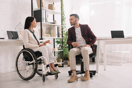 轮椅女残疾女残疾人在与办公室商业伙伴交谈时图片