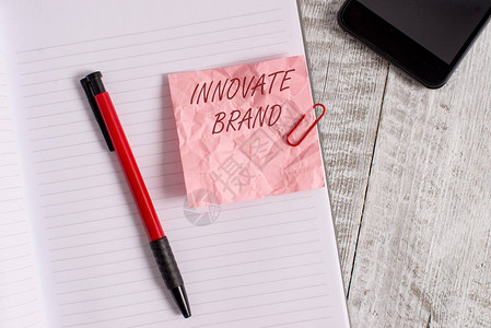 概念手写显示创新品牌概念意义对创新产品服务和更多皱纹纸笔记本和放置在木质背景上的文具有重要意义图片