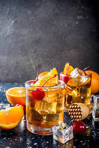 古典酒精鸡尾酒威士忌加冰块橙片和鸡尾酒红樱桃背景图片