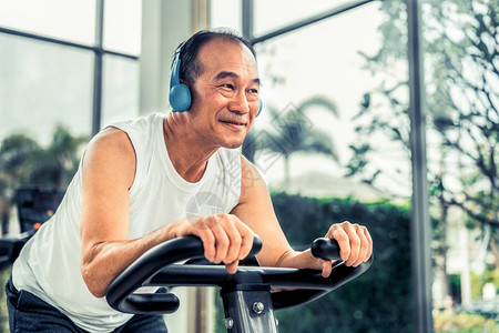 高级男子在健身中心进行骑自行车机的锻炼背景图片