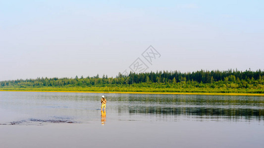 雅库特游鱼女游客站在水中旋转捕鱼图片