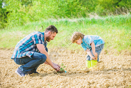 地球节快乐家谱丰富的天然土壤生态农场小男孩帮助父亲务农新生活生态工程父亲和儿子在地上图片
