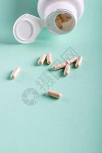 绿松石背景中的药丸药片和瓶子复制空间图片
