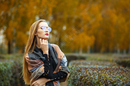 可爱的长头发金美女在秋天森林上摆姿近镜图片