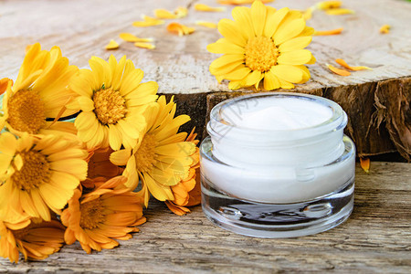一罐白化妆品奶油用于身体护理木上鲜橙色圆筒花背景图片