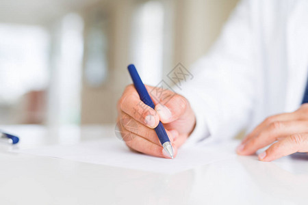 关闭在纸上写字的医生手图片