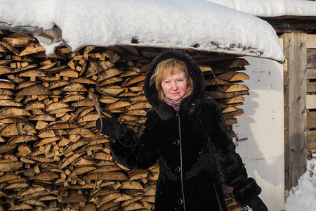 冬天穿羊皮大衣的妇女站在村里图片