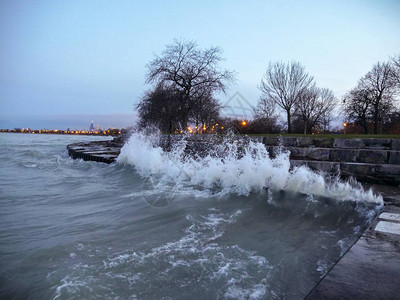 海浪在芝加哥福斯特海滩附近的波纹钢筋混凝土海岸线上撞击和溅起图片