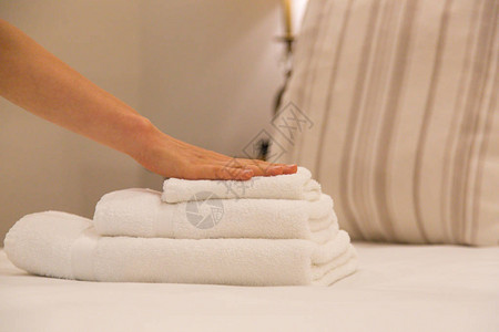 客房服务女人在酒店房间里换毛巾清洁工把毛巾放在床上图片