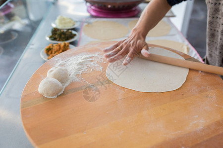 准备或制作面包或面包团的女人手用擀面杖在面团上撒面粉木桌背景上的Borek面包或糕点面团传统的土耳其馅饼皮塔饼或yu图片