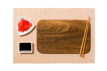 空的长方形棕色木板与筷子寿司姜和酱油棕色寿司垫背景为您设计的带有复制图片