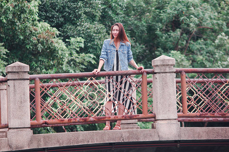 站在公园桥上的女人图片