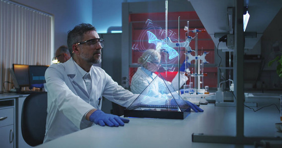 一名男科学家中镜头检查全息DNA链的图片