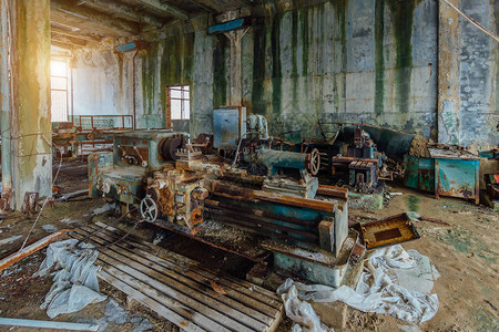 旧工业机器工具废弃的过度生产工厂中的图片