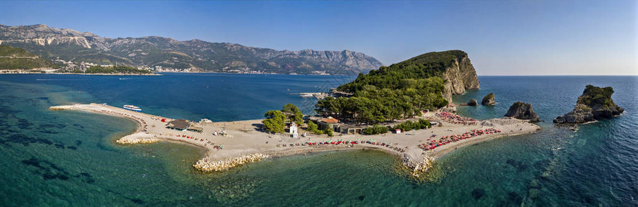 黑山的鸟瞰图夏威夷海滩遮阳伞和沐浴者以及清澈的海水锯齿状的海岸与陡峭的悬崖俯瞰着透明的大海野生自然和地中海背景图片