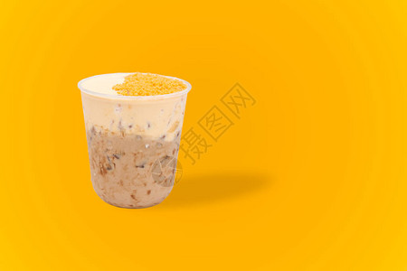 黄色背景中带咸蛋的冰奶茶图片