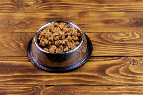 木地板金属碗中的猫或狗罐头食品图片
