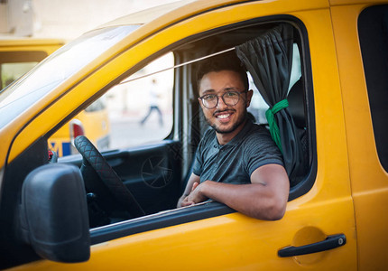 出租车司机坐在一辆黄色Caca的出租车中图片