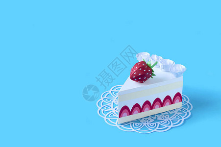 一块草莓纸蛋糕放在镂空餐巾纸上蛋糕装饰着草莓和奶油体积手工纸对象纸艺和工艺时髦的爱好极简背景图片
