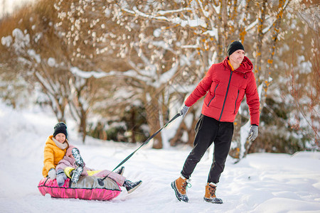 小孩子们喜欢乘坐雪橇家庭雪橇孩子们在雪地户外玩耍圣诞节前夕图片