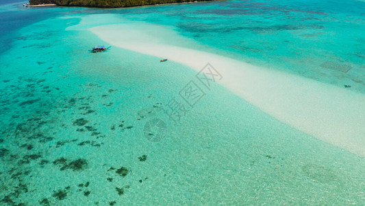 与游客在绿松石水域和珊瑚礁之间的沙滩曼萨兰甘沙洲环礁上的海滩夏季和旅游度假的概念巴拉克图片