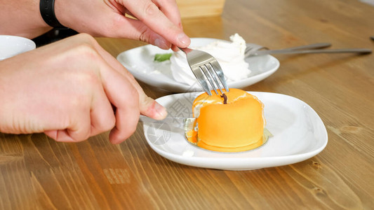 男人切下美丽的黄苹果形蛋糕图片
