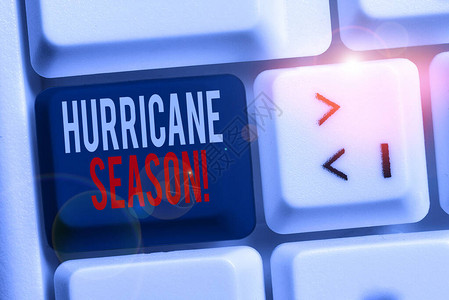 手写文字书写飓风季节预计大多数热带气旋将开发白色pc键盘的概念照片时间图片