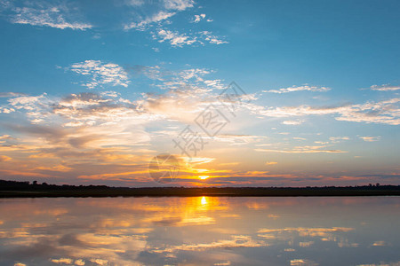 日落倒影泻湖在云层和蓝天之上的泻湖景观背景之上的美丽日落日落时有云图片